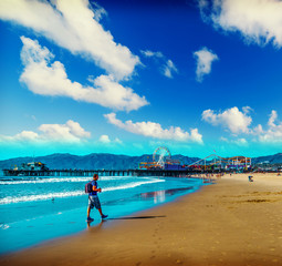 Photographer walking in world famous Santa Monica beach