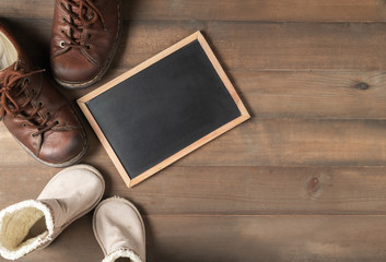 Blank blackboard with father and son brown leather boots shoes