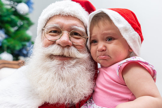 Little Baby Scared Of Santa Claus. Crying Scared At The Big White Beard.