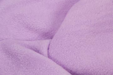 Fototapeta na wymiar The blanket of furry fleece fabric. A background soft plush fleece material with a lot of relief folds