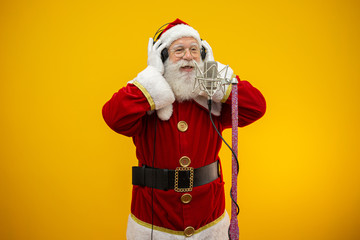Santa Claus singing or speaking in a studio microphone. Merry Christmas. Broadcaster. Announcer. Promotion. Christmas music concept.
