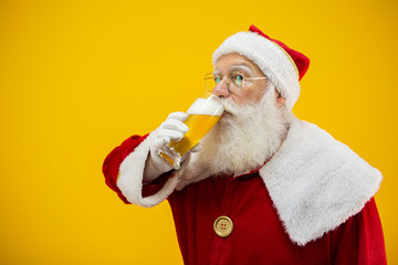 Santa Claus drinking a glass of beer. Rest time. Alcoholic drink at the holidays. Drink with moderation. Craft beer. Merry Christmas.