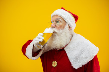 Santa Claus drinking a glass of beer. Rest time. Alcoholic drink at the holidays. Drink with moderation. Craft beer. Merry Christmas.
