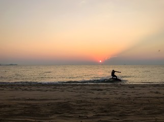 A man is surfing when sunset