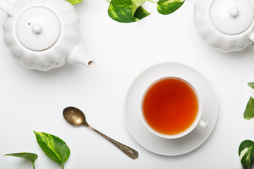 Fresh brewed tea, teapot, sugar bowl on a light table.