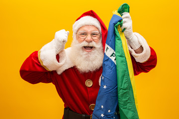 Santa Claus is a fan of Brazil. Santa Claus supporter of the Brazilian team. Sports championship. Santa Claus holding the brazilian flag. Soccer match.