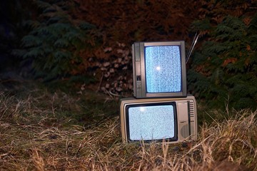 White noise and nothing on two analogue TV sets in outdoor environment