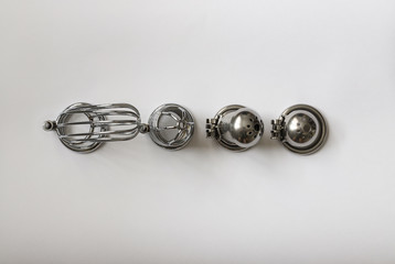 men's chastity belts of different sizes on white background