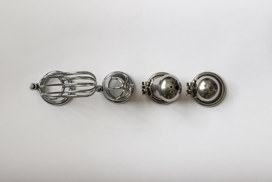 men's chastity belts of different sizes on white background