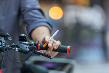 man smoking cigarette and riding a bicycle