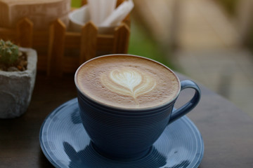 Hot latte coffee in the cafe,  latte art, breakfast at a nature background.