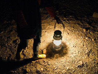 Local guide holding vintage lantern in the North cave of Thailand.