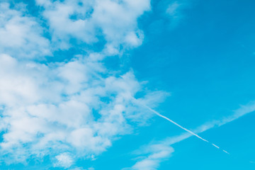 青空に浮かぶ飛行機雲と巻積雲