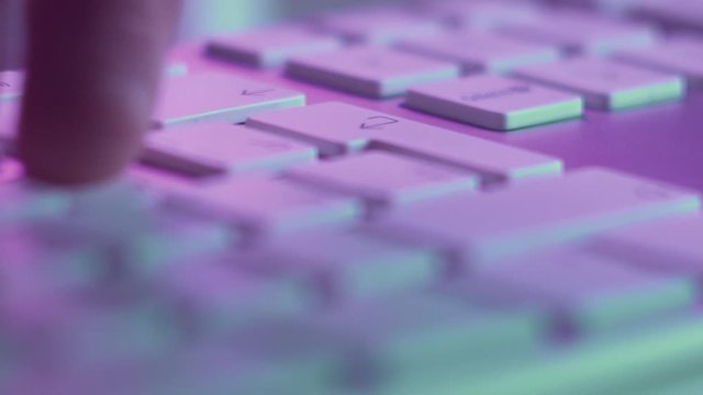 Macro Shot of Keyboard with Pressing Letter Keys and Enter. Sending Message or Typing Text in Pink Light