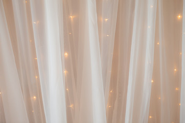 Transparent tulle with lights at the wedding ceremony, a place for photographing the groom, bride...