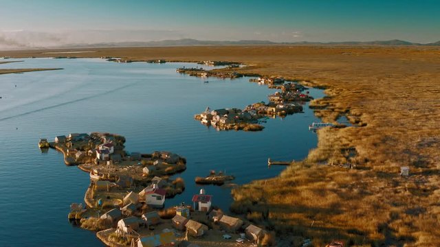 Flying above Uros Island huts towards dark Titicaca waters