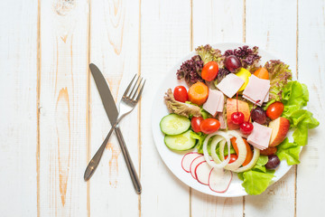 Vegetables salad on dish on white wood table