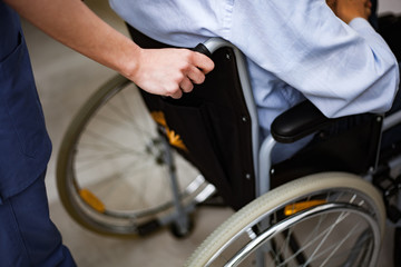 Fototapeta na wymiar Nurse pushing an injured patient on a wheelchair