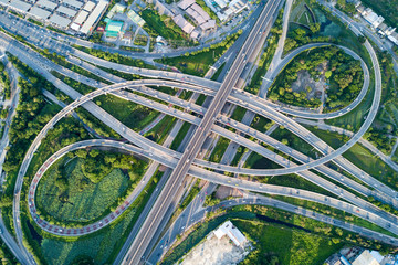 Aerial view of road interchange or highway intersection with busy urban traffic speeding on the...