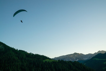 silhouette of paraglider in Dolomite mountain landscape in evening light