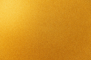 Naklejka premium Abstract gold glitter paper texture background or backdrop. Empty shimmer paper or yellow shiny paperboard for design element. Shimmering surface for christmas holiday or new year celebration concepts