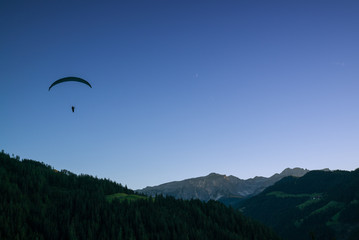 Fototapeta na wymiar silhouette of paraglider in Dolomite mountain landscape at sunset
