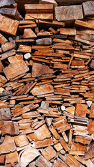 Large pile of sawn wood in different sizes and shapes in vertical format