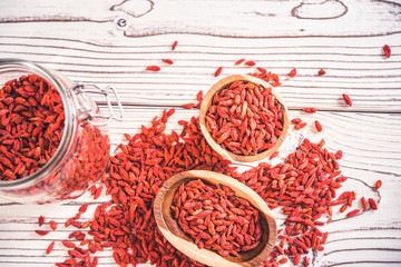 Wooden bowl with goji berries on the table closeup.top wiew