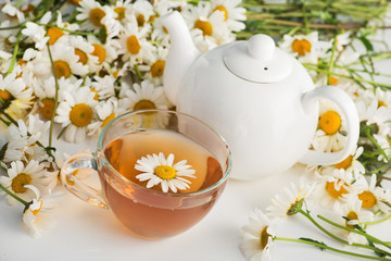 Glass cup with herbal tea with chamomile flowers