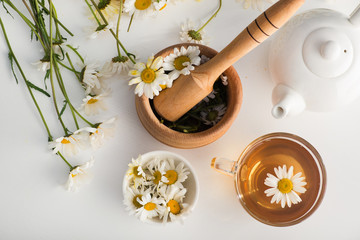 Glass cup with herbal tea with chamomile flowers