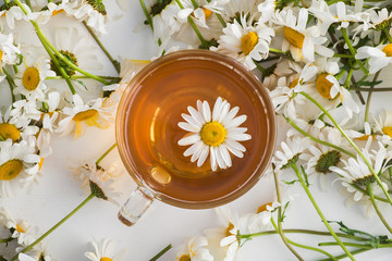 Obraz na płótnie Canvas Glass cup with herbal tea with chamomile flowers