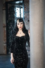 Gothic slim caucasian girl in black tight dress posing in her room