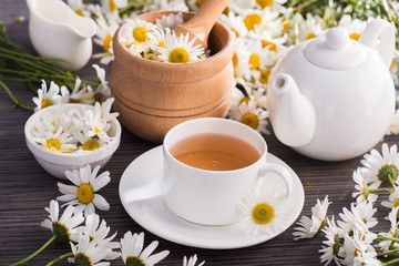 Cup of chamomile herbal tea with flowers