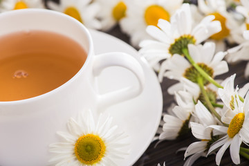 Cup of chamomile herbal tea with flowers