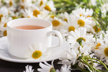 Cup of chamomile herbal tea with flowers