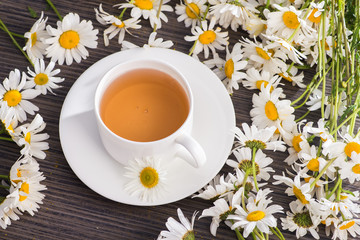 Cup of chamomile herbal tea with flowers