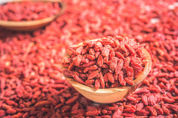 Wooden bowl with goji berries on the table closeup