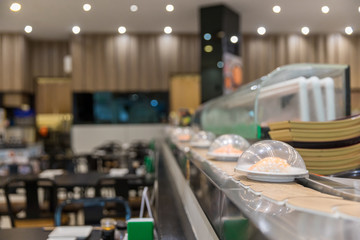 Japan restaurant sushi conveyor or belt buffet. belt sushi in japan restaurant with blurred background.