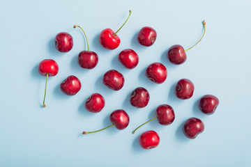 Obraz na płótnie Canvas Red fresh cherries on a blue pastel color