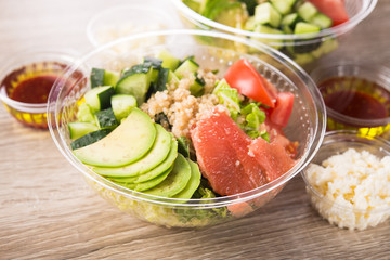 Plastic take away container with fresh salad consists of cucumber, avocado, tomato, grapefruit