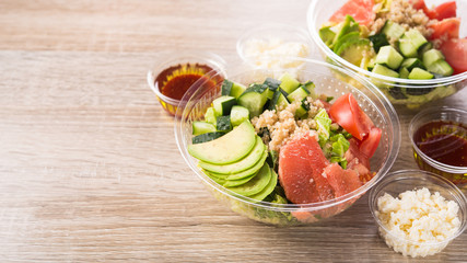 Plastic take away container with fresh salad consists of cucumber, avocado, tomato, grapefruit