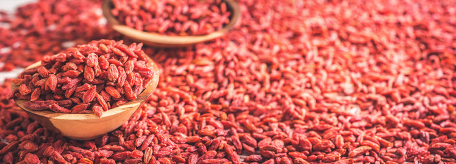 Wooden bowl with goji berries on the table closeup. panorama