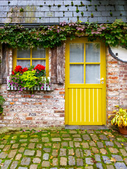 Fototapeta na wymiar Beautiful old cozy yellow painted house at Durbuy - the smallest city of the world, Province of Luxembourg, Belgium, exterior facade partial view