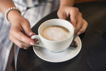 Young girl in a cafe with a coffee cup