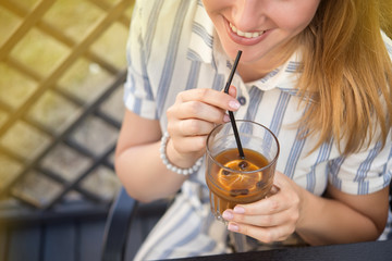 Woman holding a cold summer cocktail with coffee beans