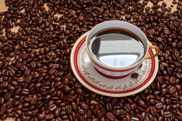 cup of coffee and beans on wooden background
