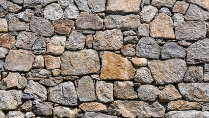 Muro de contención de piedras grandes planas, con diferentes colores y tamaños