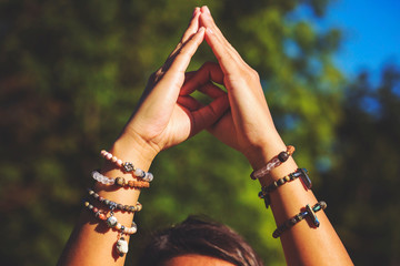 Female hands in yoga mudra and natural mineral stone bead bracelets