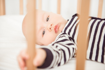 Newborn baby lying in bed in striped clothes
