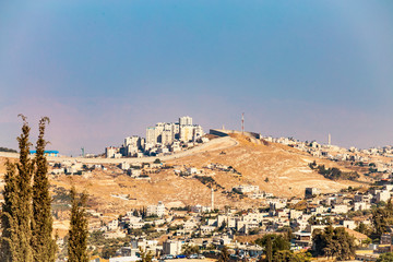 Obraz premium Small village and the Israeli West Bank barrier or wall - separation barrier on the West Bank in Israel. View from Montefiore Windmill